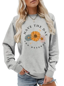 Detail of floral graphic and text print on a light grey crewneck sweatshirt for women