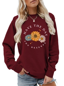Detail of burgundy crewneck sweatshirt with flower print and Have the day you deserve text