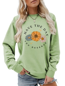 Close-up of the floral print and Have The Day You Deserve text on a green sweatshirt