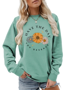 Detail of mint green sweatshirt featuring daisy print and HAVE THE DAY YOU DESERVE slogan
