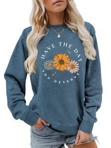 Detail of sunflower print and Have The Day You Deserve text on blue crewneck sweatshirt