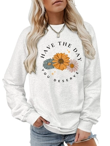 Close-up of crewneck sweatshirt showing daisy floral print and text on light grey fabric