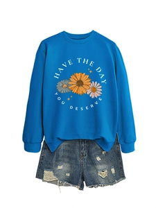 Detail of blue floral graphic sweatshirt with have the day you deserve text and ripped shorts