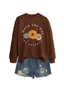 Flat lay of brown crewneck sweatshirt with daisy print and ripped denim shorts set