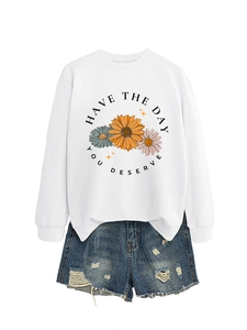 Flat lay of white crewneck sweatshirt with flower print and ripped denim shorts set