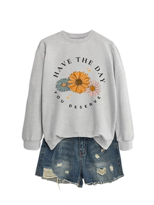 Close-up of light grey crewneck sweatshirt with sunflower print and blue denim shorts