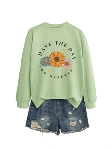 Detail of mint green sweatshirt with daisy print and HAVE THE DAY YOU DESERVE slogan