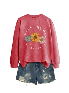 Detail of red crewneck sweatshirt with sunflower print and Have The Day You Deserve slogan