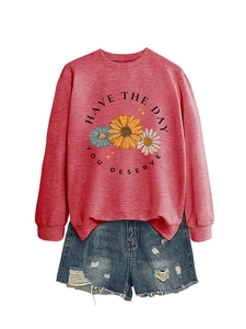 Flat lay of pink crewneck sweatshirt with sunflower print and 'Have the day you deserve' text
