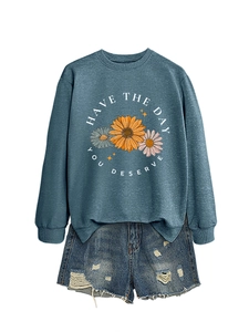 Flat lay of gray blue crewneck sweatshirt with daisy print and ripped denim shorts