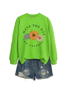 Detail of neon green daisy sweatshirt with 'HAVE THE DAY YOU DESERVE' print and denim shorts