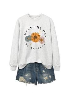 Flat lay of gray crewneck sweatshirt with sunflower print and ripped denim shorts set