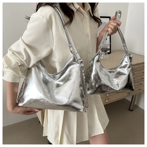 Detail of silver metallic hobo bags featuring embossed logo and decorative metal chain