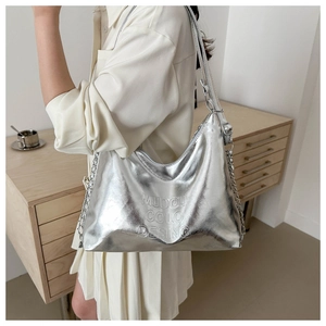 Silver metallic hobo bag with chain strap detail and embossed logo on soft surface