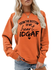 Detail of orange sweatshirt featuring black typography and ribbed elastic cuffs