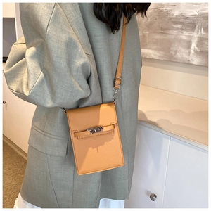 Close-up of ginger leather mini crossbody phone bag with classic metal turn-lock closure