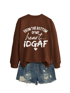 Detail of a brown sweatshirt with white heart slogan print and ripped denim shorts