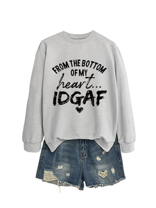 Detail of light grey crewneck sweatshirt with heart print and ripped denim shorts set