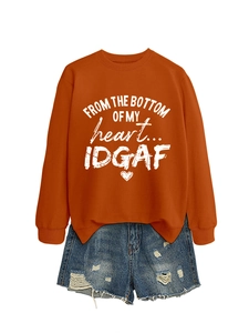 Detail of bright orange sweatshirt with white typography print and side slit hem