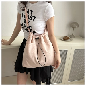 Minimalist light pink nylon drawstring bag with shoulder strap for casual daily use