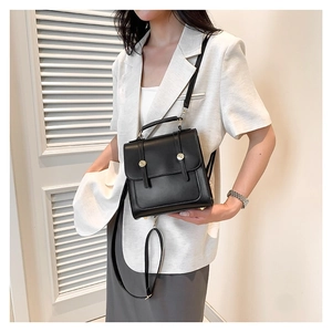 Chic black structured backpack for women featuring stylish gold circular buckles and handle