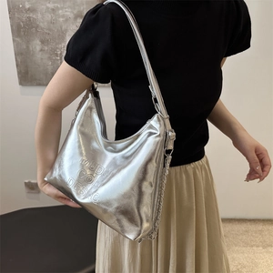 Silver metallic hobo bag with adjustable strap and chain detail for women shown on model