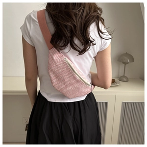Dettaglio del marsupio in tweed rosa e bianco con tracolla regolabile e zip argento