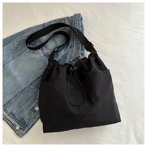 Detail of black canvas drawstring bag with adjustable strap and side pockets for daily use