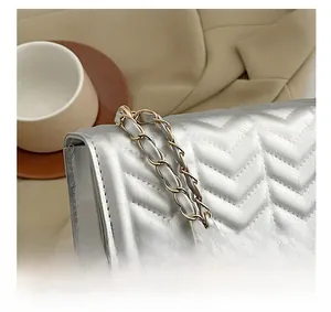Detailed close-up of silver chevron quilted flap bag with metallic chain strap detail