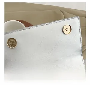 Macro detail of the dual magnetic buckle closure on a silver metallic chain bag