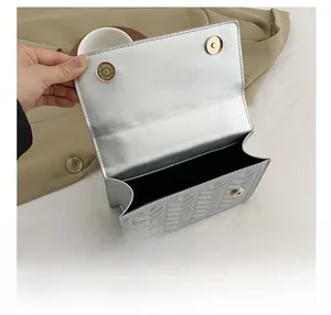 Detail view of the silver chevron quilted crossbody bag with magnetic closures and interior