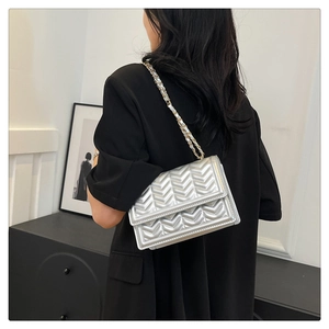 Detail of silver chevron quilted crossbody bag with stylish leather chain strap
