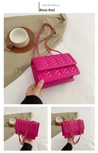 Macro detail of rose red chevron quilted PU leather flap bag with gold chain strap