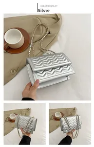 Detail of silver chevron quilted crossbody bag with metallic finish and chain strap