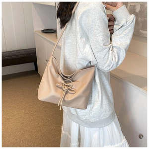 Minimalist beige drawstring hobo shoulder bag with a bow detail for casual style