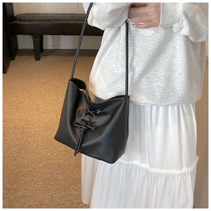 Detail of ballet style shoulder bag with criss-cross drawstring on matte leather