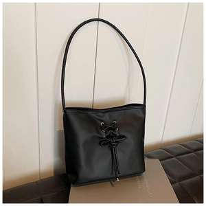 Minimalist black PU leather shoulder bag with decorative cross-lacing and bucket design