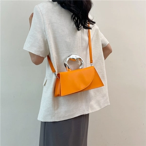 Vibrant orange geometric handbag with unique silver handle styled with a white blazer