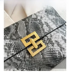 Détail d'une pochette motif serpent avec fermoir métallique doré vintage