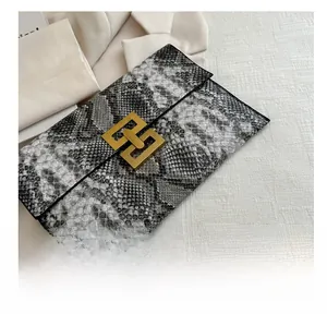 Détail de la pochette enveloppe motif serpent avec fermoir métallique géométrique doré