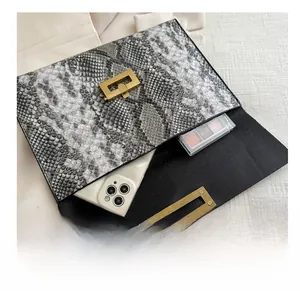 Détail de la pochette enveloppe serpent montrant la capacité pour téléphone et maquillage