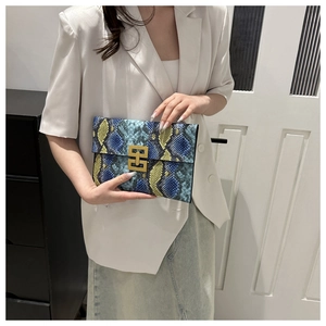 Détail de la pochette enveloppe à motif serpent avec boucle métallique dorée géométrique