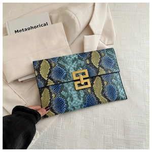 Détail d'une pochette enveloppe à motif serpent avec boucle métallique dorée vintage