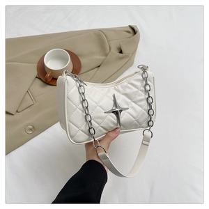 Close-up of white quilted underarm bag with silver star charm and chain strap detail