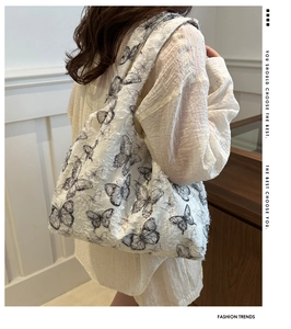 Detail of white chiffon tote bag featuring black butterfly patterns and 3D textured fabric