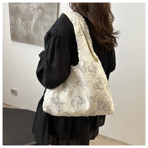 Detail of soft cream chiffon tote with grey butterfly pattern and textured fabric surface