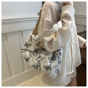 Close-up of white chiffon tote bag featuring black butterfly prints and pleated texture