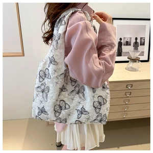 Chiffon tote bag showing its large capacity and butterfly pattern on a female model