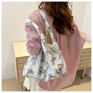 Close-up of white chiffon bucket bag with black butterfly prints and velvet texture
