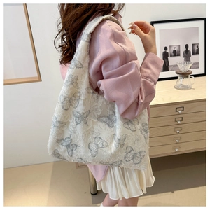 Detailed back view of a large chiffon tote bag with gray butterfly prints on a model